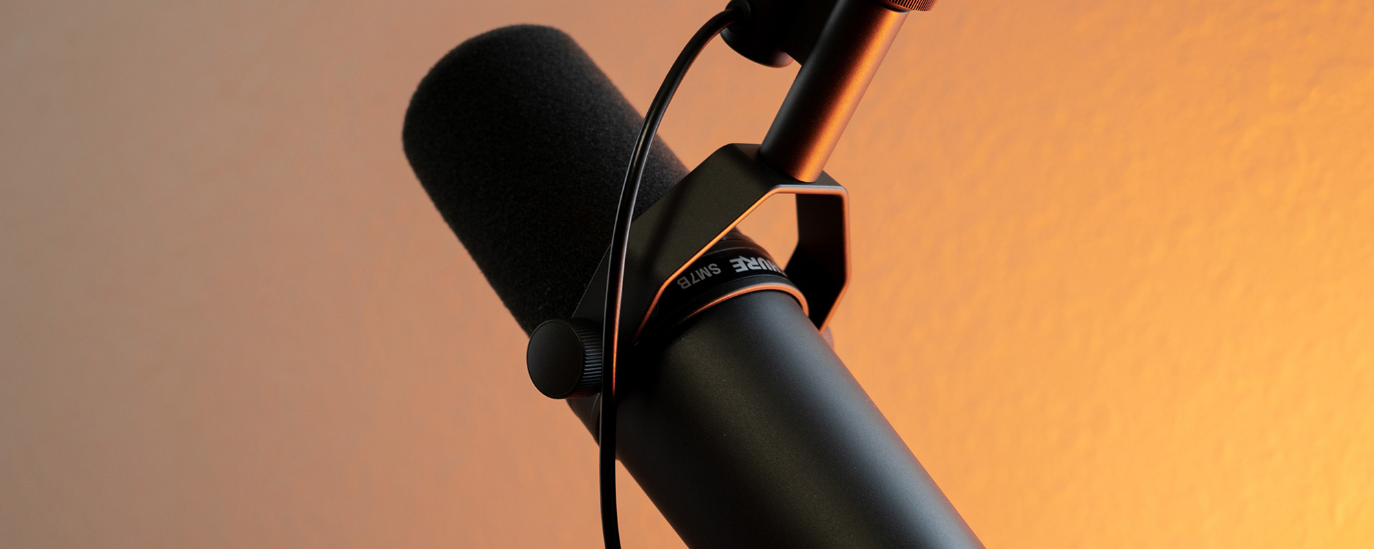 Ein hochwertiges Podcast-Mikrofon steht in einem professionellen Studio, umgeben von einer warmen, orangefarbenen Beleuchtung. Diese Szene symbolisiert den "Hilfe zur Selbsthilfe" Podcast des Unfallopfer-Hilfswerks, der Unfallopfern wertvolle Informationen und Unterstützung bietet. Hier entstehen Inhalte zu Themen wie Unterstützung nach einem Unfall, Unfallbewältigung, Selbsthilfe-Strategien und Beratung für Unfallopfer. Der Experten-Podcast vermittelt praxisnahe Tipps und gibt wertvolle Einblicke in rechtliche und organisatorische Fragen, um Betroffenen Orientierung und Hilfe zur Selbsthilfe zu bieten.