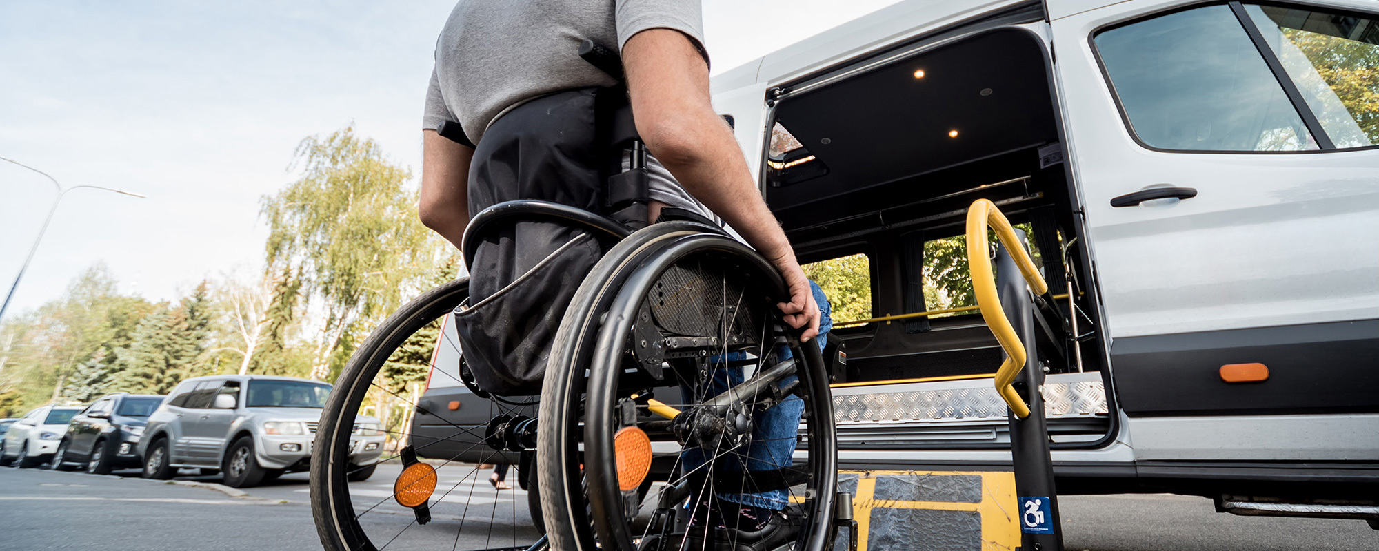 Ein Rollstuhlfahrer fährt über eine Rampe in ein speziell ausgestattetes Transportfahrzeug für Rollstühle. Dieses Behindertenfahrzeug bietet maximale Flexibilität für barrierefreies Reisen und ermöglicht einen entspannten Urlaub mit dem Rollstuhl. Das Unfallopfer-Hilfswerk stellt diese Fahrzeuge zu günstigen Tarifen zur Verfügung, um barrierefreie Mobilität zu gewährleisten und einen barrierefreien Urlaub für Menschen mit Behinderung zu erleichtern.